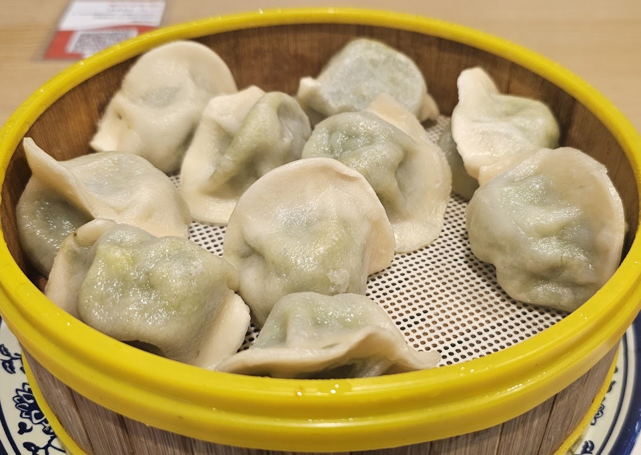 Steamed dumplings in a yellow bamboo-style basket